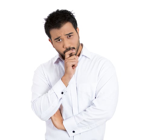 Closeup portrait of unhappy young man thinking daydreaming deeply bothered by something chin on hand looking at you, isolated on white background. Negative emotion facial expression feeling